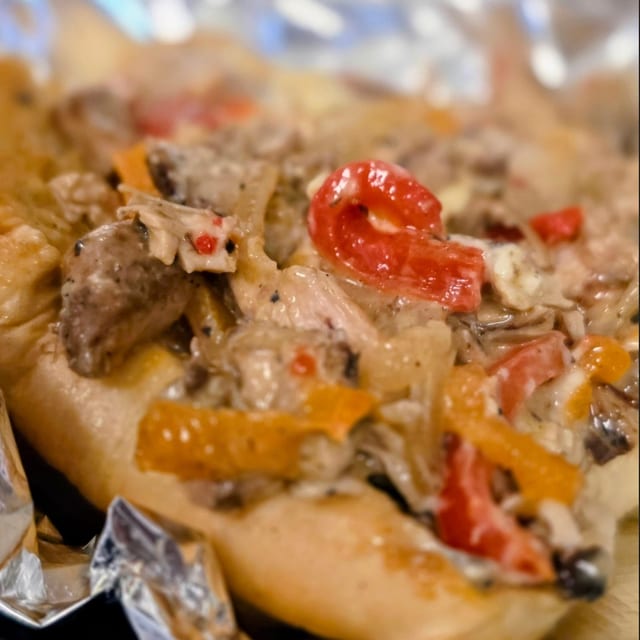 Mini Jerk Chicken Cheesesteak with Peppers and Onions.